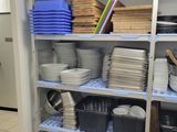 many plates and pans on the shelves in the kitchen