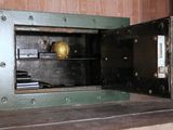 a small metal safe box with a clock inside of it