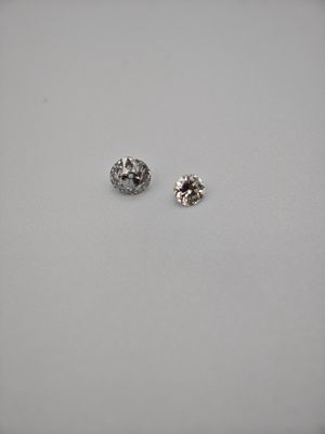 a pair of diamond earrings sitting on top of a white surface