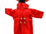 une poupée qui porte un manteau rouge et un bonnet rouge