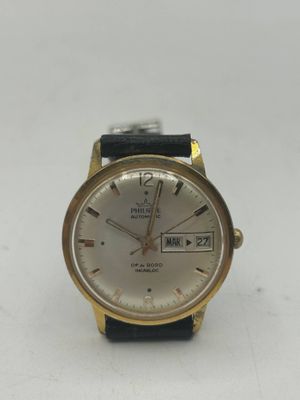 un gros plan d'une montre sur une surface blanche avec un fond blanc