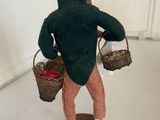 a figurine of a man with a basket of strawberries