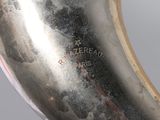 a close up of a silver vase with a black label on it