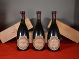three bottles of wine sitting on a table next to a wooden box