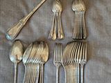 four silver spoons and a spoon with a spoon rest on a table