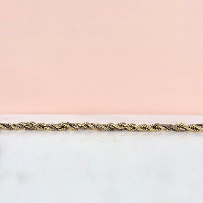 un gros plan d'une corde dorée posée sur une surface en marbre