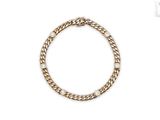 gros plan d'un bracelet en chaîne en or sur fond blanc