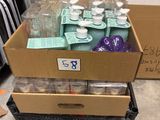 une boîte remplie de tasses et d'assiettes posée par terre