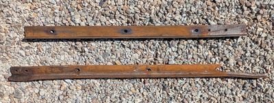 pair of old rusted iron door handles on gravel surface