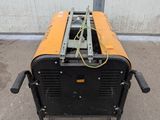 an orange and black machine sitting on top of a cement floor