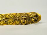 a gold figurine of a man and a woman with leaves on it