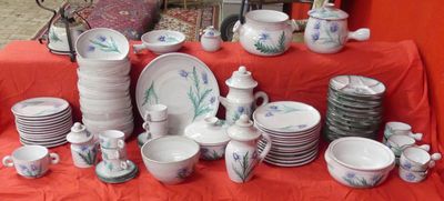 many plates and cups on a table with a red table cloth