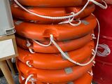 de nombreux gilets de sauvetage orange empilés les uns sur les autres