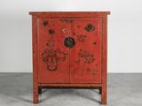 une vieille armoire rouge décorée de fleurs et d'oiseaux peints