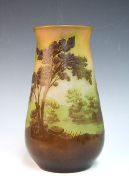 un vase avec un tableau posé sur une table