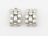 two pairs of silver earrings on a white surface with a white background