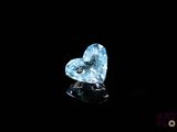 une topaze bleue en forme de cœur sertie de diamants sur un fond noir