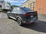 the rear end of a grey car parked in a parking lot