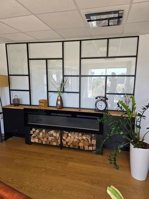 une cheminée au milieu d'une pièce où il y a beaucoup de bois