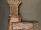 an old leather holster with a leather strap on a gray background