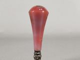 a small red vase with a silver base on a table