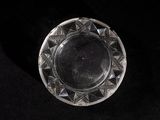 une plaque de verre ornée d'un motif, posée sur une surface noire