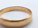 a close up of a gold ring on a white surface
