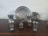 a lot of silver vases on a wooden table