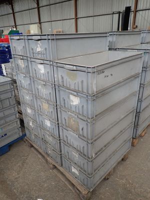 une grande pile de conteneurs métalliques dans un entrepôt