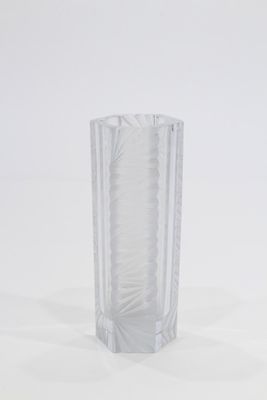 un vase en verre transparent posé sur une surface blanche
