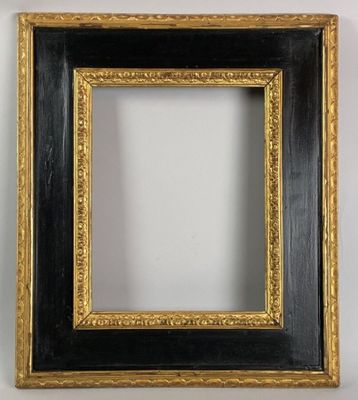 un cadre noir et doré, bordé d'or, accroché à un mur blanc