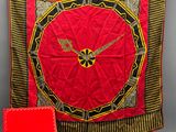 an image of a red and black clock on a red blanket