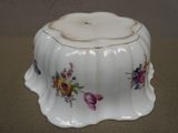 un bol blanc orné de fleurs, posé sur une table