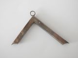 a close up of a metal triangle on a white surface