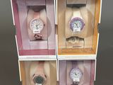 three boxes with four different watches inside of them on a table