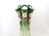 a green vase with pink flowers on it on a white background