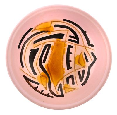 une assiette rose sur laquelle se trouve un morceau de nourriture