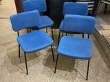 quatre chaises bleues posées sur un sol en béton, à côté d'une poubelle