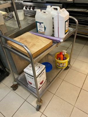 a metal cart with a cutting board on it in a kitchen