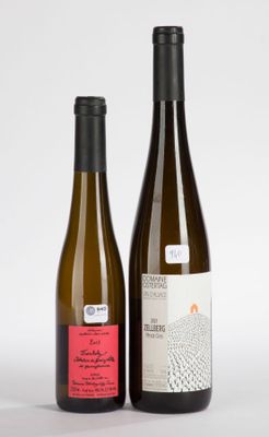 two bottles of wine sitting next to each other on a white surface