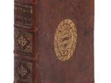 un vieux livre orné d'un emblème doré sur la couverture