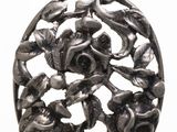 une image représentant un pendentif en argent orné de fleurs et de feuilles