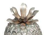 a metal pineapple with a flower on top of it