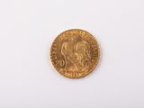 a close up of a gold coin on a white surface