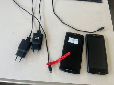 three cell phones and a keyboard on a table