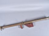 an old brass telescope on a white surface with a wooden handle