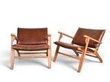 pair of brown leather lounge chairs on white background