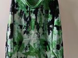 green and black tie dye hoodie hanging on a hanger