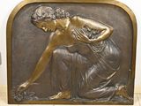 une plaque en bronze représentant une femme avec un panier de fleurs