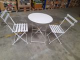 a white table and four chairs in a warehouse